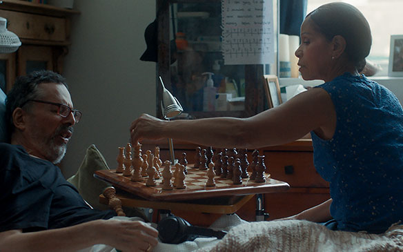 Une femme joue aux échecs avec son mari, au lit Une femme joue aux échecs avec son mari, au lit